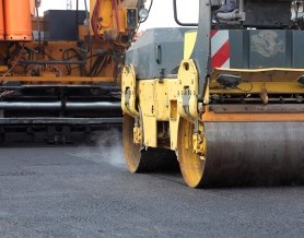 Paving equipment rolling over fresh asphalt